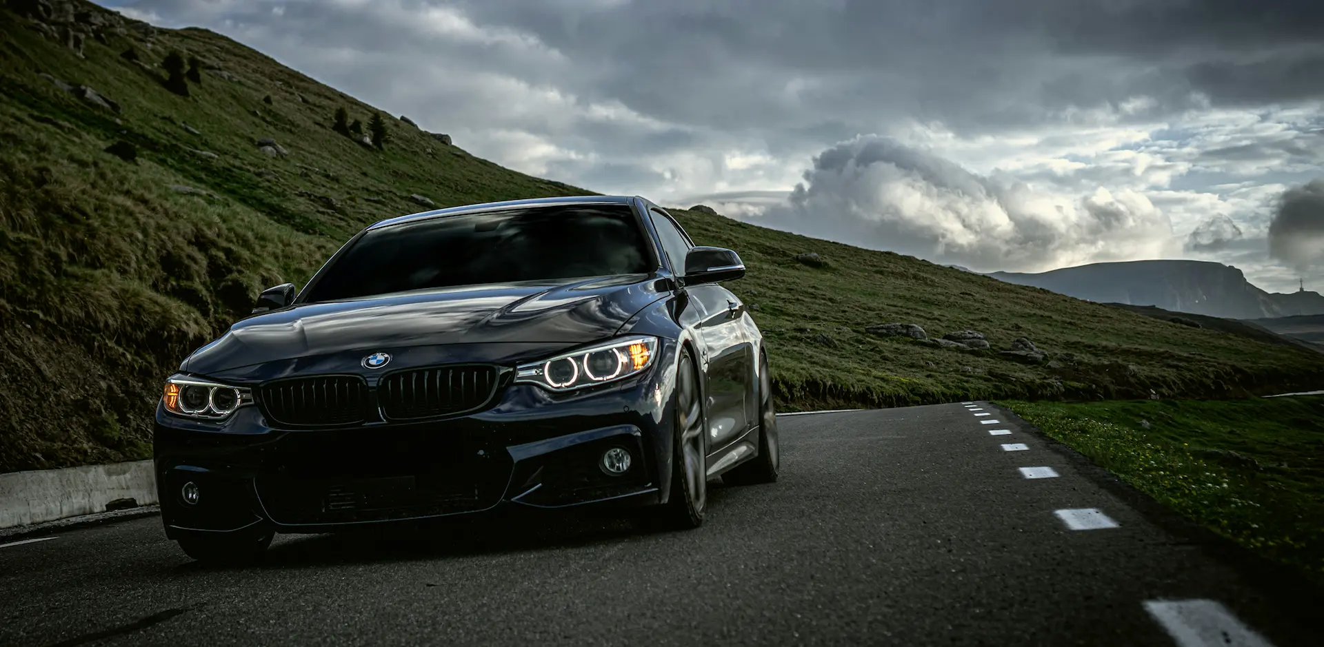 Een zwarte BMW rijd met snelheid door de bergen.